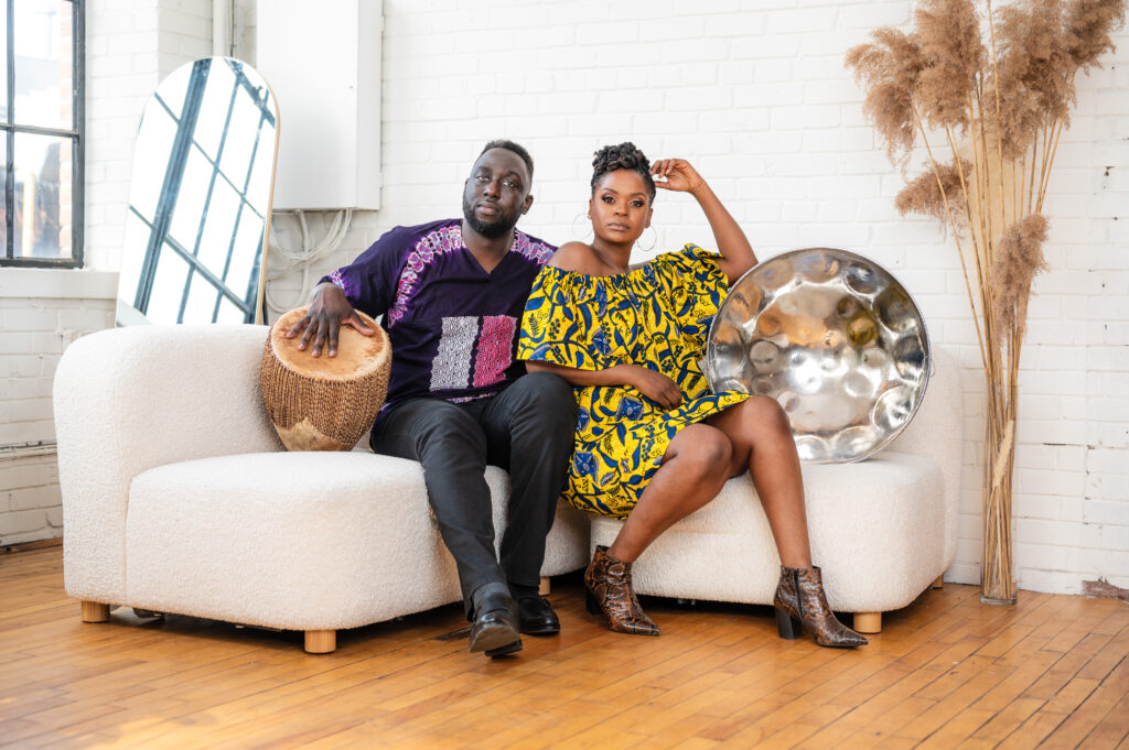 Larnell and Joy on a couch with a steel pan and bongo